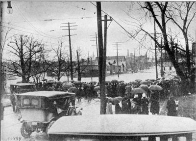 Crowds at the end of one of the streets which was turned into a racing river. Many persons floating down on the debris were rescued by willing hands as they neared this point